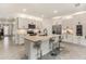 Well-lit kitchen with a large island, stainless steel appliances, granite countertops and light gray cabinets at 8990 Forge Breeze Loop, Wesley Chapel, FL 33545