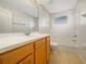 Bathroom with wood vanity, large mirror, and a shower-tub combo at 9003 Willowbrook Cir, Bradenton, FL 34212