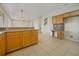 Open kitchen area with wood cabinets, neutral counters, tile backsplash and light tile flooring at 9003 Willowbrook Cir, Bradenton, FL 34212