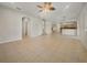 Large living room featuring tile flooring, ceiling fan, and staircase access to upper level at 9003 Willowbrook Cir, Bradenton, FL 34212