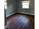 Bedroom featuring light gray paint, 2 windows, and dark hard wood floors at 910 Seminole St, Clearwater, FL 33755