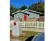 Charming single-story home featuring a red front door, a spacious porch and a white picket fence at 910 Seminole St, Clearwater, FL 33755