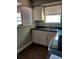 Cozy kitchen featuring white cabinets, black countertops, and a stainless steel sink under a window at 910 Seminole St, Clearwater, FL 33755