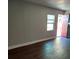 Inviting living room with hard surface floors, neutral paint, and a red door at 910 Seminole St, Clearwater, FL 33755