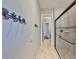 Bathroom hallway with travertine floors leading to a glass shower and decorative seashell hangers at 912 Symphony Beach Ln, Apollo Beach, FL 33572