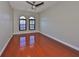 Spacious bedroom featuring gleaming hardwood floors and arched windows with plantation shutters at 912 Symphony Beach Ln, Apollo Beach, FL 33572