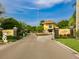 Community entrance featuring a guard house, gate, and lush tropical landscaping at 912 Symphony Beach Ln, Apollo Beach, FL 33572