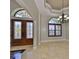 Elegant entryway with marble floors, decorative front door, and an arched window with shutters at 912 Symphony Beach Ln, Apollo Beach, FL 33572