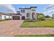 Two-story home with a three-car garage, manicured landscaping, and clay tile roof at 912 Symphony Beach Ln, Apollo Beach, FL 33572