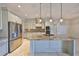 Kitchen featuring marble floors, stainless steel appliances, and a large center island at 912 Symphony Beach Ln, Apollo Beach, FL 33572