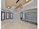 Open-concept living room featuring tray ceilings, marble floors, and plantation shutters at 912 Symphony Beach Ln, Apollo Beach, FL 33572