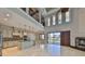 Bright open-concept living area with travertine floors, high ceilings, fireplace, and sliding glass doors to the pool area at 912 Symphony Beach Ln, Apollo Beach, FL 33572