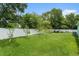 Lush green backyard enclosed by a pristine white fence, providing a secure and private outdoor space at 9321 Regatta Cir, Spring Hill, FL 34606