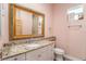 Bathroom with granite vanity, framed mirror and step-in shower behind the door at 9321 Regatta Cir, Spring Hill, FL 34606