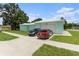 Home featuring a two-car garage and a driveway with two parked cars at 9321 Regatta Cir, Spring Hill, FL 34606