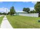 Exterior view of home with a vinyl fence, lawn, and sidewalk access at 9321 Regatta Cir, Spring Hill, FL 34606