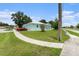 Exterior view of home with a green lawn, driveway, and sidewalk access at 9321 Regatta Cir, Spring Hill, FL 34606