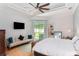 Bright main bedroom featuring white bedding, ceiling fan, and access to the backyard at 9321 Regatta Cir, Spring Hill, FL 34606