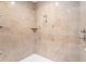 Spacious tiled shower with multiple shower heads and a built-in shelf for toiletries at 9321 Regatta Cir, Spring Hill, FL 34606