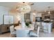 Open concept dining area with modern chandelier, white table with seating, and view of kitchen and living room at 9806 Crescent Moon Dr, Riverview, FL 33578