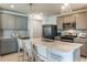 Kitchen with grey cabinets, stainless steel appliances, island with barstool seating and modern light fixtures at 9806 Crescent Moon Dr, Riverview, FL 33578