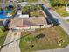 Aerial view of a single-story home featuring a driveway, lawn, fenced yard, and neighborhood street at 5117 Cape Cod Dr, Holiday, FL 34690