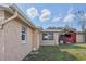 Exterior shot features the back of the home and a separate shed and well maintained lawn at 5117 Cape Cod Dr, Holiday, FL 34690