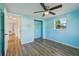 Bedroom with wood-look floors, closet, ceiling fan, and natural light from window at 5117 Cape Cod Dr, Holiday, FL 34690