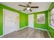 A secondary bedroom features a ceiling fan, wood flooring, and bright green paint at 5117 Cape Cod Dr, Holiday, FL 34690