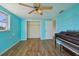 Bedroom with wood-look floors, ceiling fan, closet, and natural light from the window at 5117 Cape Cod Dr, Holiday, FL 34690