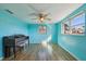 Bedroom with wood-look floors, ceiling fan, and natural light from two windows at 5117 Cape Cod Dr, Holiday, FL 34690