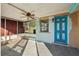 View of a screened patio with a ceiling fan and a decorative blue door at 5117 Cape Cod Dr, Holiday, FL 34690