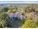 Aerial view of the home with a screened in pool, lush landscaping, and waterway views at 1011 Riverside Ridge Rd, Tarpon Springs, FL 34688