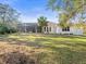 View of the rear of the house, featuring a screened-in porch, and a well-maintained lawn at 1011 Riverside Ridge Rd, Tarpon Springs, FL 34688