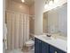 Well-maintained bathroom featuring a shower with curtain, vanity with sink and blue cabinets at 1011 Riverside Ridge Rd, Tarpon Springs, FL 34688