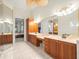 Bright bathroom with double sinks, wooden cabinets, and a view to the bedroom at 1011 Riverside Ridge Rd, Tarpon Springs, FL 34688