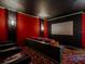 Comfortable home theater with large screen, colorful carpet, and tiered seating for an immersive experience at 1011 Riverside Ridge Rd, Tarpon Springs, FL 34688