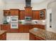 Functional kitchen with wooden cabinetry, granite countertops, double ovens, and tile flooring at 1011 Riverside Ridge Rd, Tarpon Springs, FL 34688