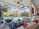 Enclosed lanai with comfortable seating, ceiling fan, and views of the sparkling pool and backyard at 1011 Riverside Ridge Rd, Tarpon Springs, FL 34688