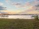Scenic waterfront view showcasing a boat dock and the tranquil lake at sunset at 1011 Riverside Ridge Rd, Tarpon Springs, FL 34688