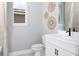 Well-lit bathroom with a modern vanity, toilet, and a window with decor at 12339 Hearts Ease St, Venice, FL 34293