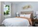 Cozy bedroom with a statement headboard, neutral color scheme, and a bright window with a pleasant view at 12339 Hearts Ease St, Venice, FL 34293