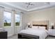 Serene main bedroom with large windows, a tray ceiling, and a neutral color palette at 12339 Hearts Ease St, Venice, FL 34293