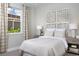 Inviting bedroom with a decorative headboard, neutral color scheme, and a bright window at 12339 Hearts Ease St, Venice, FL 34293
