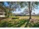 A vast backyard featuring mature trees, manicured landscaping, and a screened-in pool enclosure at 13255 Don Loop, Spring Hill, FL 34609
