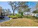 A spacious backyard featuring lush landscaping, mature trees, and a screened-in pool area at 13255 Don Loop, Spring Hill, FL 34609
