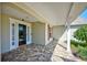 Cozy covered porch featuring brick pavers, white columns, and a glass-paneled front door at 13255 Don Loop, Spring Hill, FL 34609