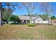 Charming single-story home with a well-maintained front yard, mature trees, and an American flag at 13255 Don Loop, Spring Hill, FL 34609