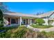 Inviting home exterior with lush landscaping, brick walkway, front porch, and red shutters at 13255 Don Loop, Spring Hill, FL 34609
