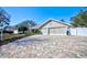 Charming single-story home features a brick-paved driveway and a spacious two-car garage with a neutral color palette at 13255 Don Loop, Spring Hill, FL 34609